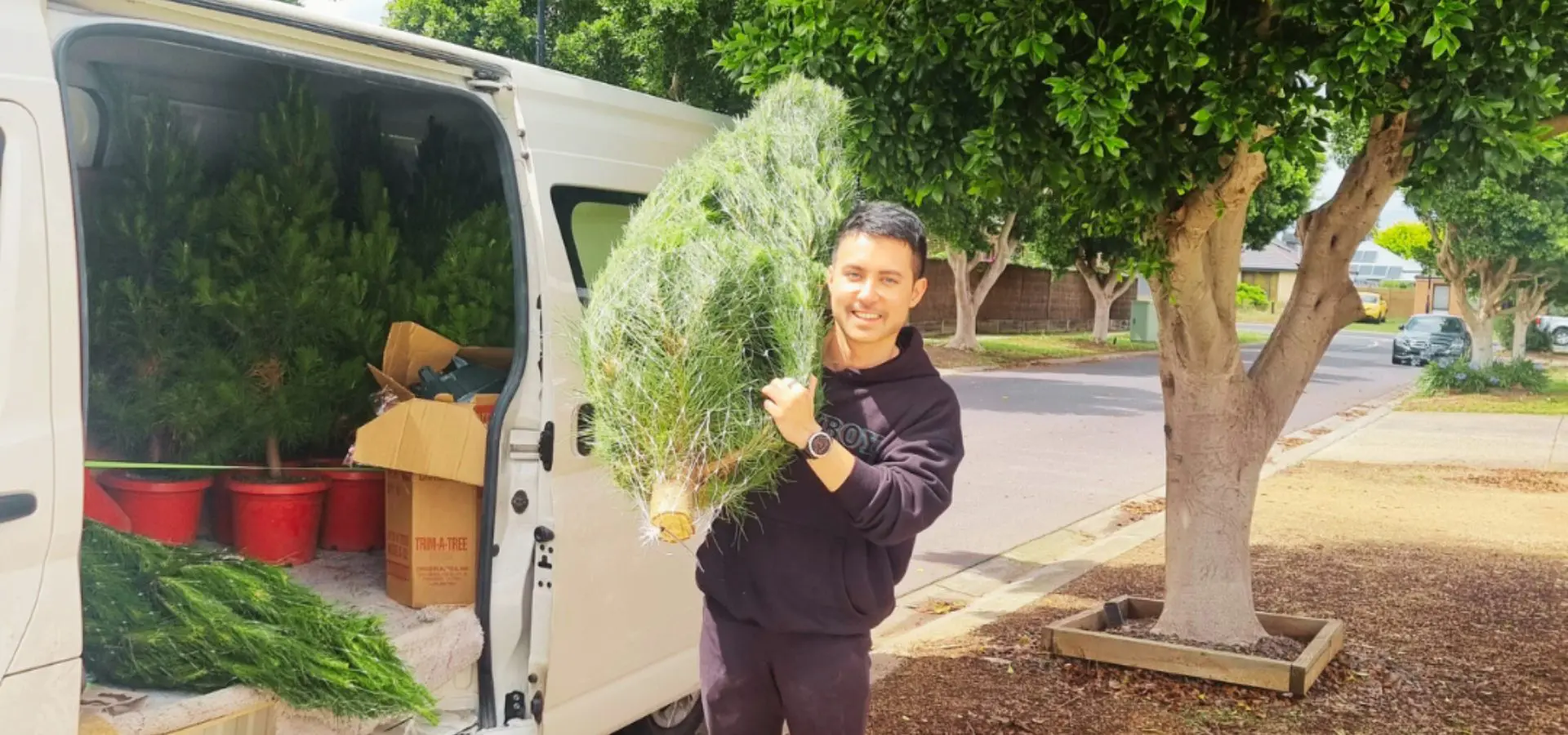 a man holding a real christmas tree for delivery