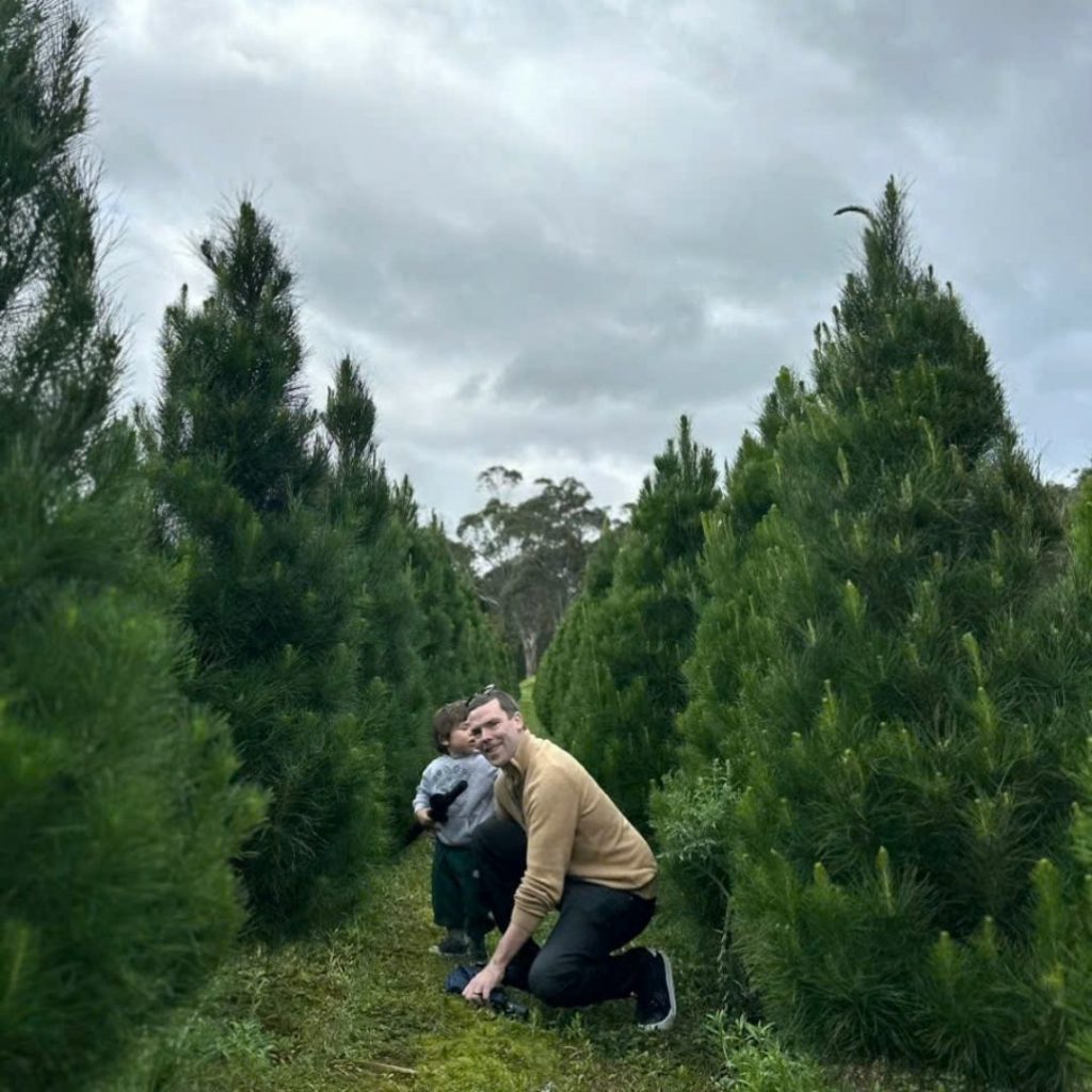 a man and child in a real christmas tree farm